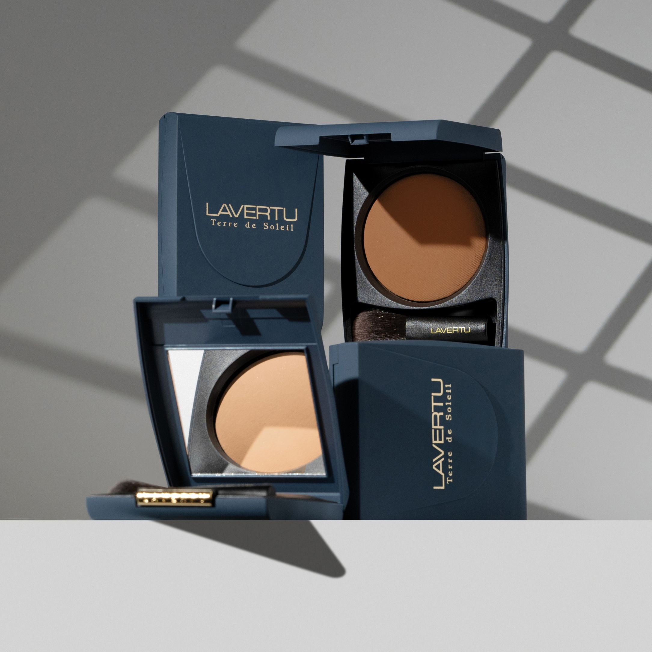 LAVERTU Terre de Soleil Bronzer collection with open and closed compacts, showcasing the warm baked formula and mini brush.